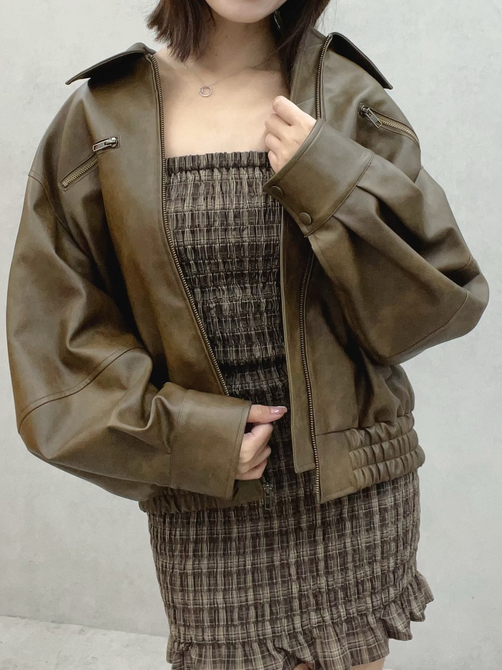 ブラウン系のワンピース、ブラウン系のブルゾン、ホワイト系のブーツを着用したレディースの秋コーディネートの7枚目の写真