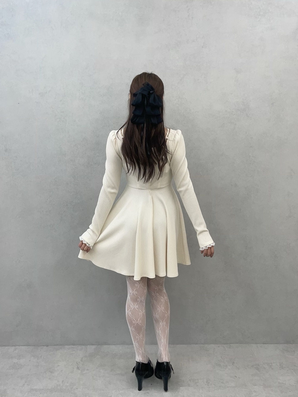 ホワイト系のワンピース、ブラック系のブーツを着用したレディースの冬コーディネートの7枚目の写真