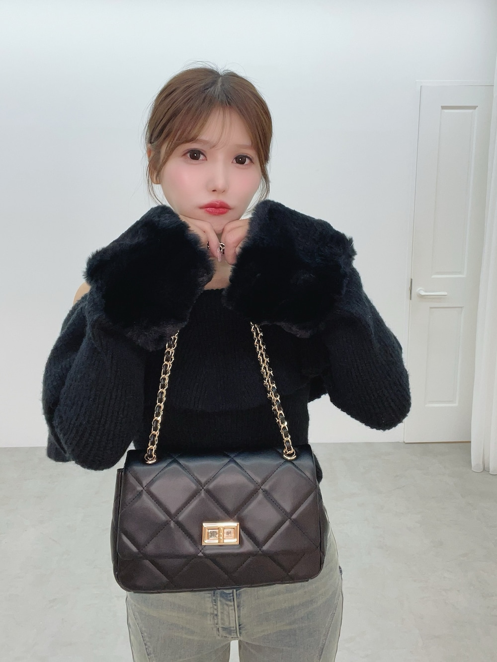 ブラック系のハンドバッグ、ブルー系のデニムパンツ、ブラック系のニット/セーターを着用したレディースの秋コーディネートの10枚目の写真