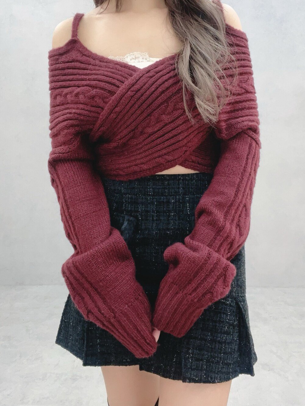 ブラック系のブーツ、ブラック系のスカート、レッド系のニット/セーターを着用したレディースの冬コーディネートの5枚目の写真