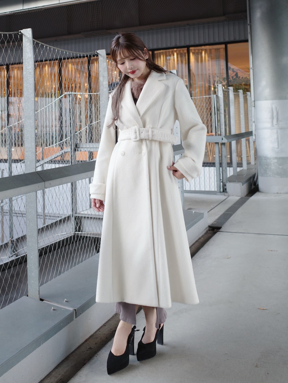 ホワイト系のその他アウター、ブラック系のハンドバッグを着用したレディースの冬コーディネートの6枚目の写真