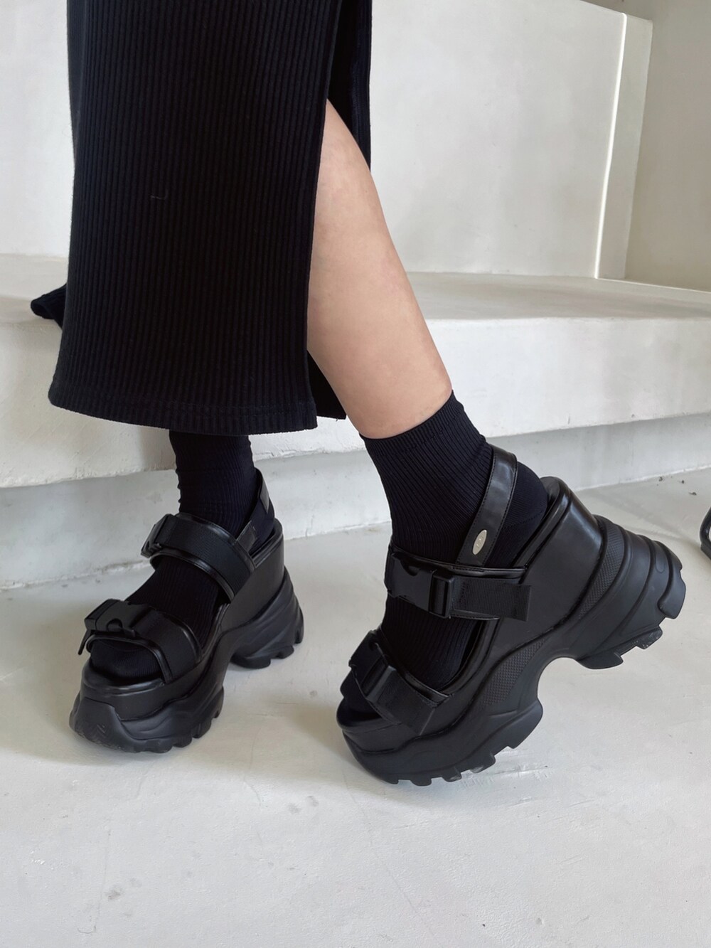 ブラック系のワンピース、ブラック系のサンダルを着用したレディースの春コーディネートの6枚目の写真