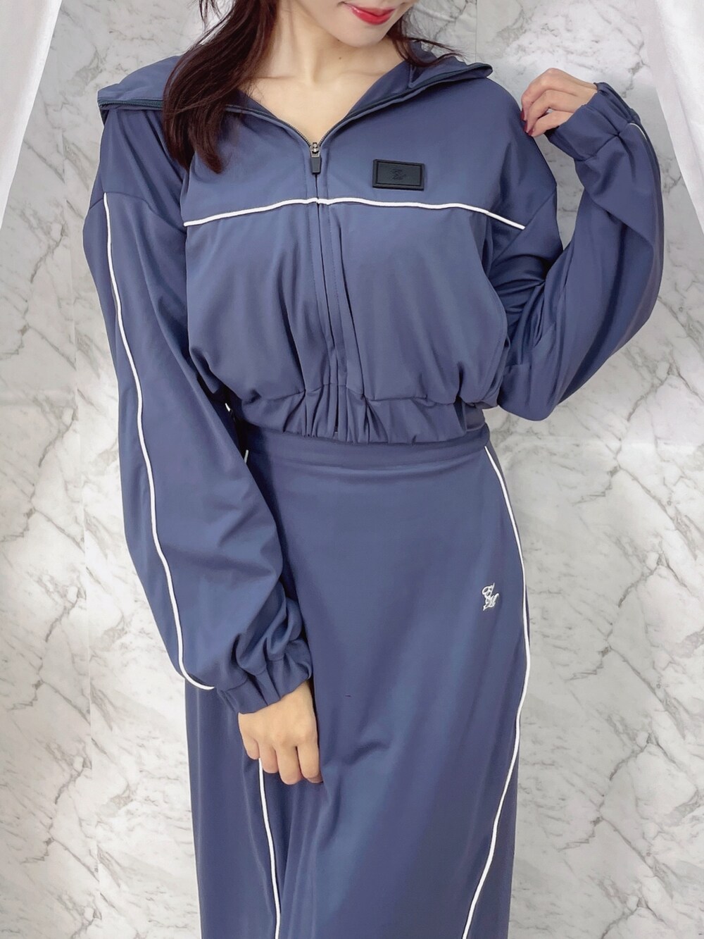 ブルー系のナイロンジャケット、ブルー系のスカートを着用したレディースの秋コーディネートの6枚目の写真