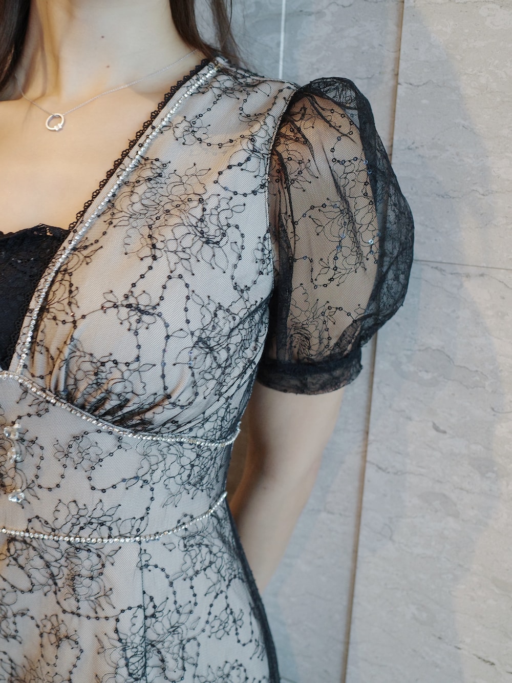 ブラック系のハンドバッグ、ブラック系のパンプス、その他のワンピースを着用したレディースの夏コーディネートの4枚目の写真