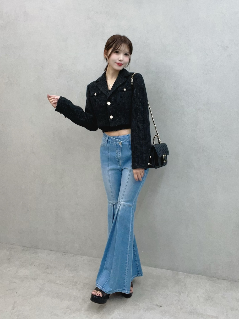 ブルー系のデニムパンツ、ブラック系のサンダル、ブラック系のテーラードジャケットを着用したレディースの秋コーディネートの2枚目の写真
