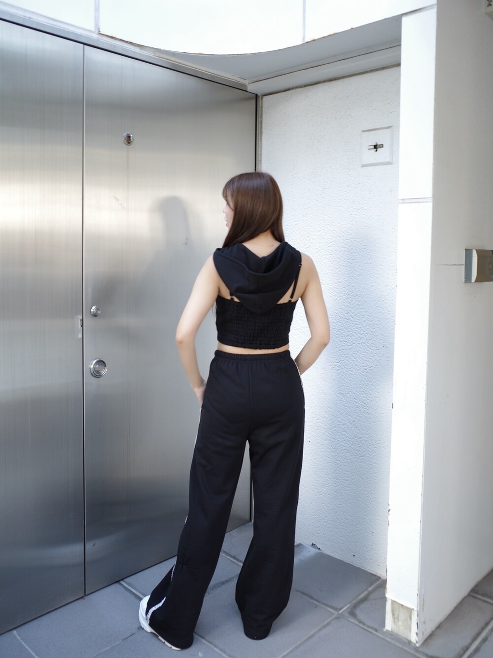 ブラック系のキャミソール、ブラック系のスウェットパンツ、ホワイト系のスニーカーを着用したレディースの夏コーディネートの5枚目の写真