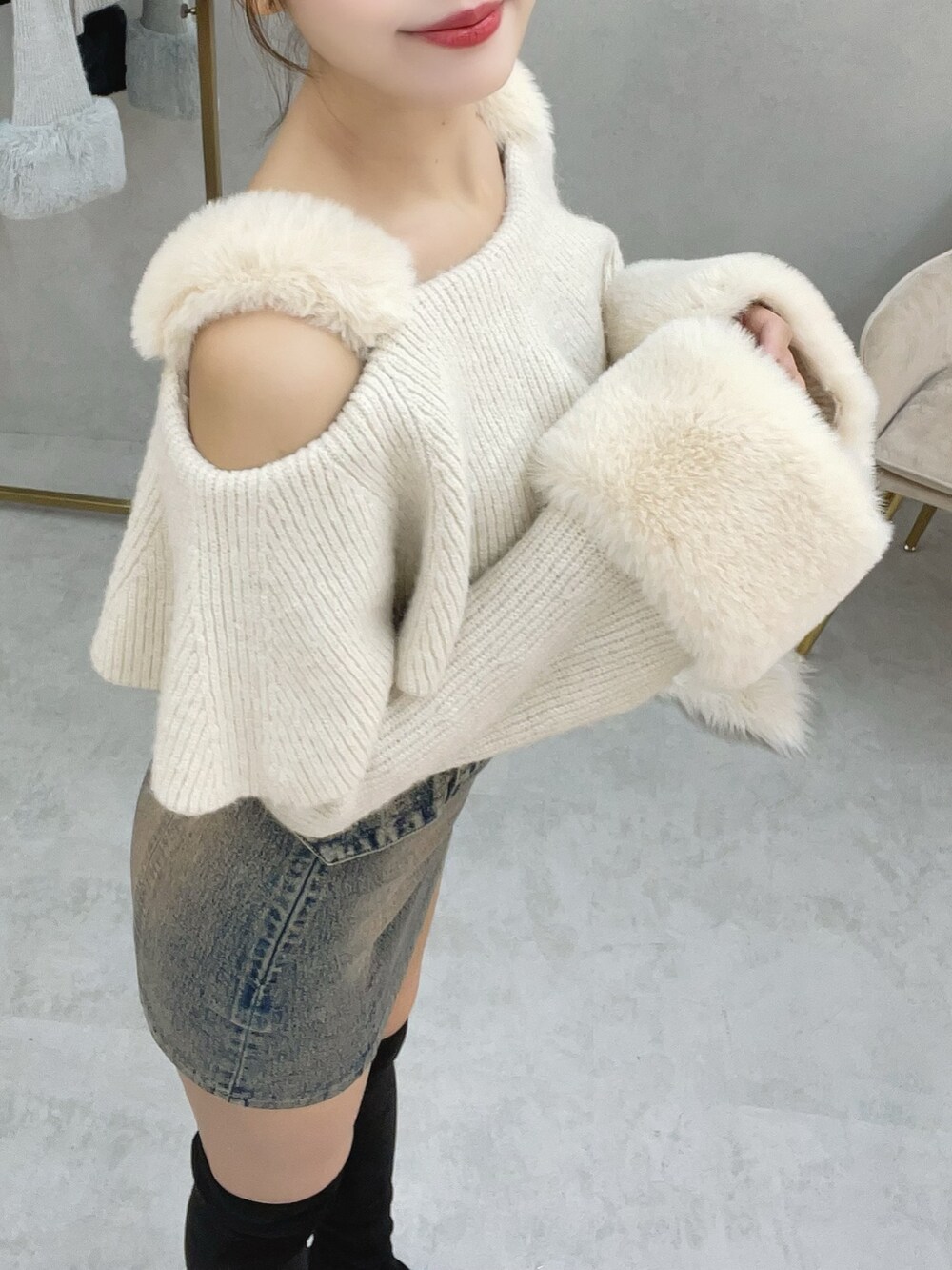 ホワイト系のニット/セーター、ブルー系のデニムスカート、ブラック系のブーツを着用したレディースの秋コーディネートの4枚目の写真