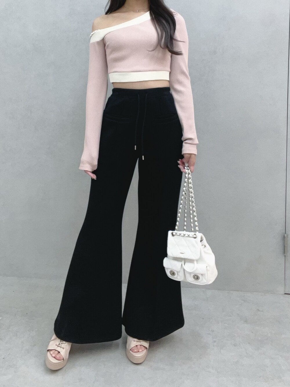 ピンク系のTシャツ/カットソー、ブラック系のその他パンツ、ホワイト系のバックパック/リュックを着用したレディースの冬コーディネートの2枚目の写真