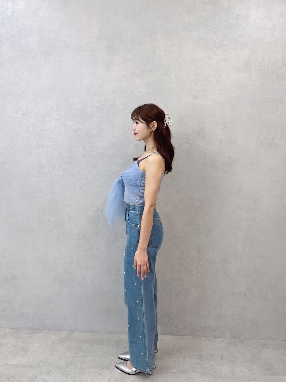 ブルー系のキャミソール、ブルー系のデニムパンツ、シルバー系のネックレスを着用したレディースの夏コーディネートの5枚目の写真