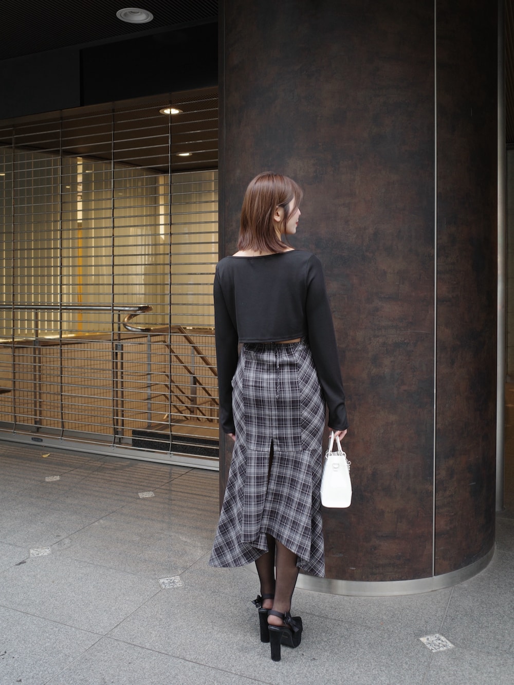 ブラック系のワンピース、ホワイト系のハンドバッグを着用したレディースの秋コーディネートの5枚目の写真