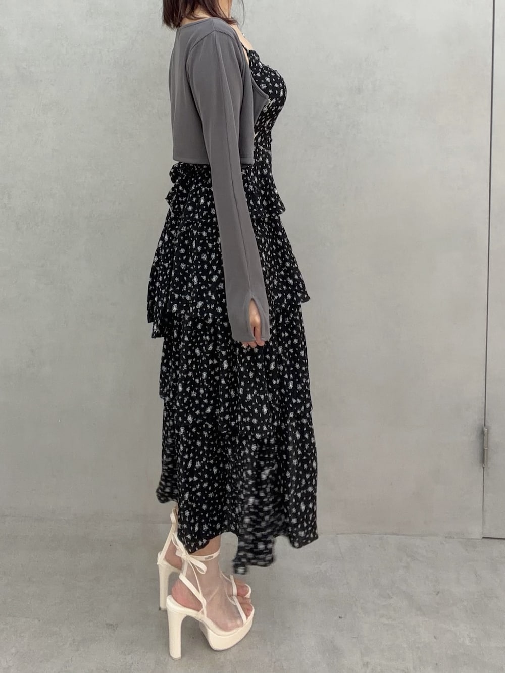 ブラック系のワンピース、ホワイト系のサンダル、グレー系のTシャツ/カットソーを着用したレディースの冬コーディネートの3枚目の写真