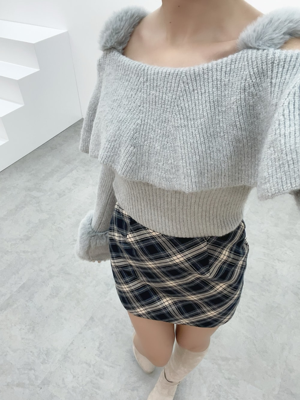 グレー系のニット/セーター、ホワイト系のブーツ、ブルー系のスカートを着用したレディースの秋コーディネートの7枚目の写真