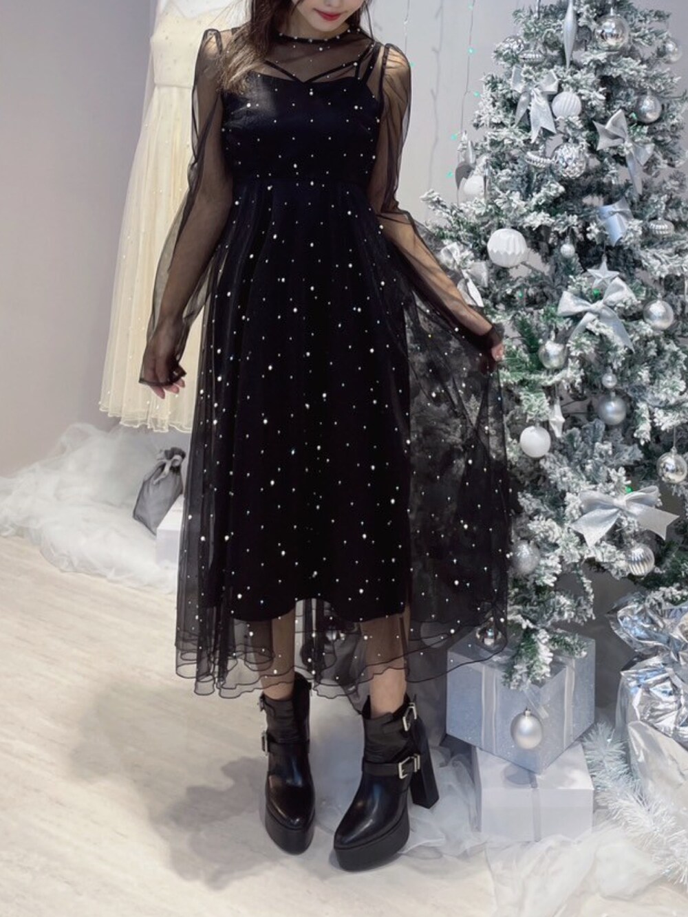 ブラック系のワンピース、ブラック系のブーツを着用したレディースの秋コーディネートの5枚目の写真