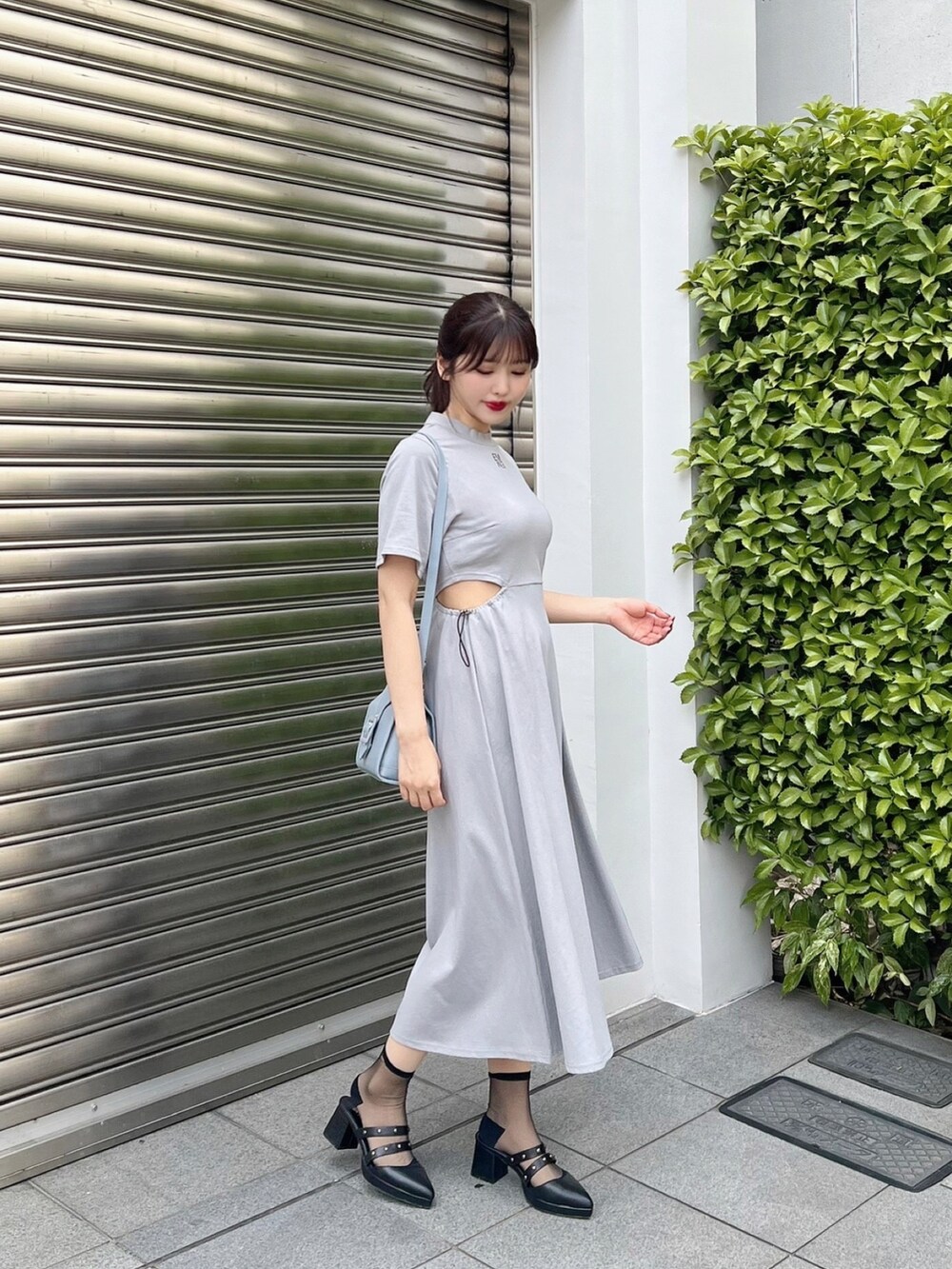 ブルー系のワンピース、ブルー系のハンドバッグ、ブラック系のパンプスを着用したレディースの夏コーディネートの3枚目の写真