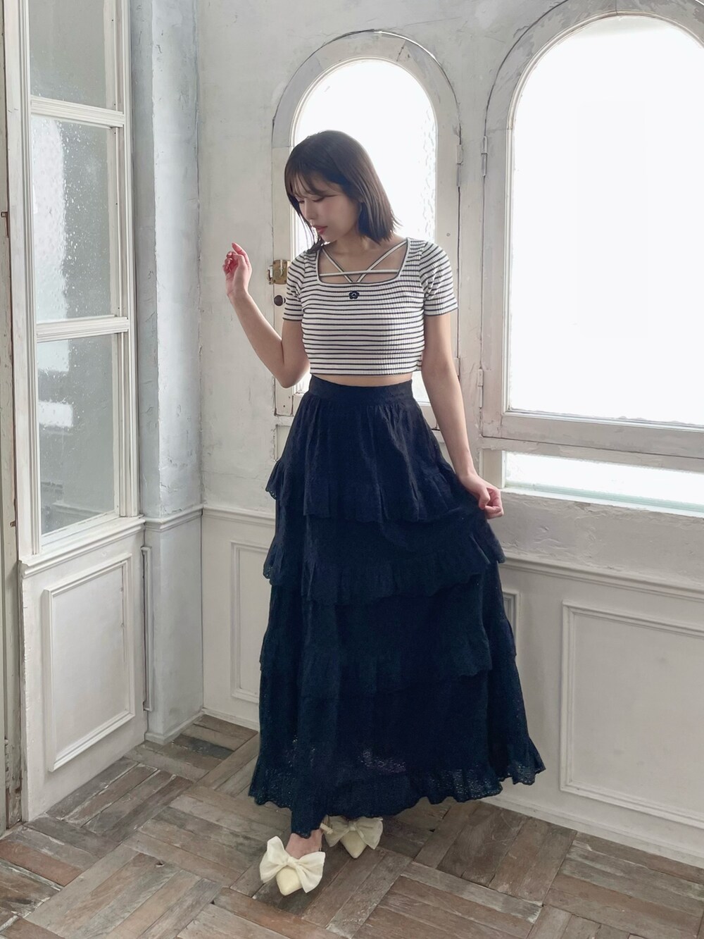 ブラック系のスカート、イエロー系のパンプス、その他のTシャツ/カットソーを着用したレディースの春コーディネートの2枚目の写真