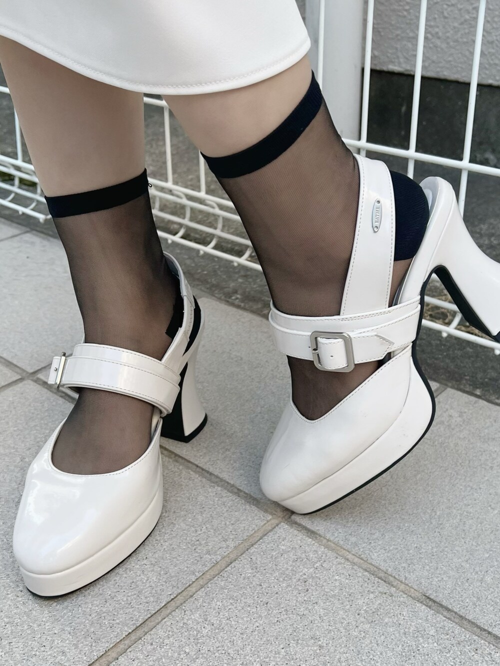 ホワイト系のワンピース、ホワイト系のパンプス、その他のピアス（両耳用）を着用したレディースの夏コーディネートの6枚目の写真