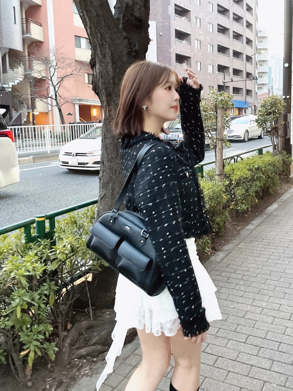 ブラック系のテーラードジャケット、ホワイト系のTシャツ/カットソー、ブラック系のボストンバッグを着用したレディースの春コーディネートの10枚目の写真