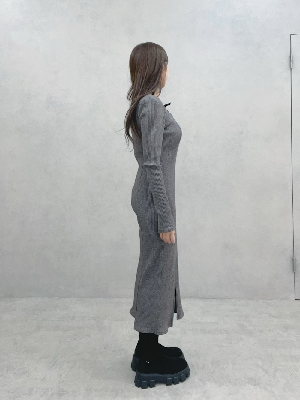 グレー系のワンピース、ブラック系のブーツを着用したレディースの冬コーディネートの4枚目の写真