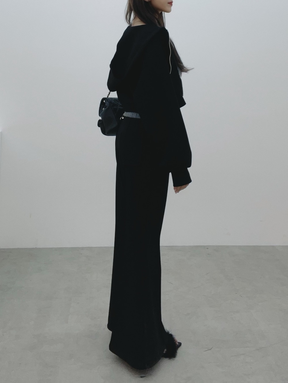 ブラック系のパーカー、ブラック系のバックパック/リュック、グレー系のニット/セーターを着用したレディースの冬コーディネートの3枚目の写真