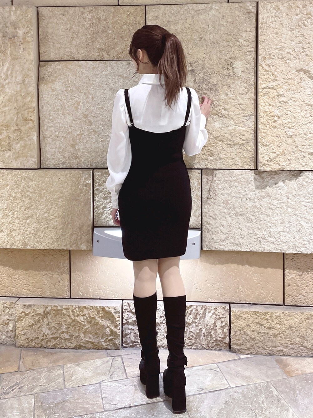 ブラック系のワンピース、ブラック系のブーツを着用したレディースの冬コーディネートの6枚目の写真