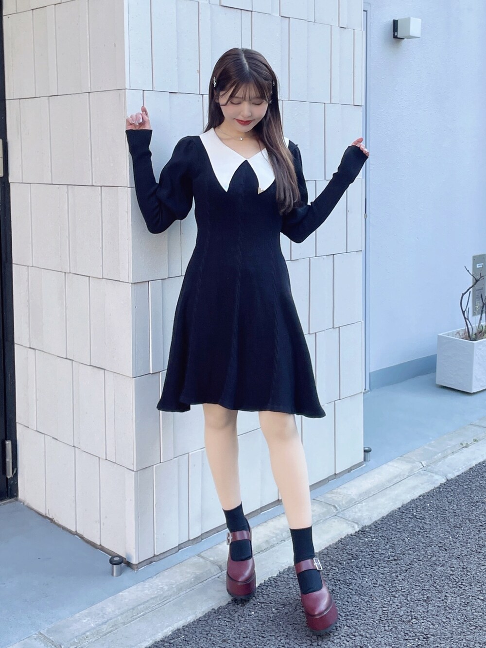 ブラック系のワンピース、レッド系のパンプス、シルバー系のネックレスを着用したレディースの冬コーディネートの3枚目の写真