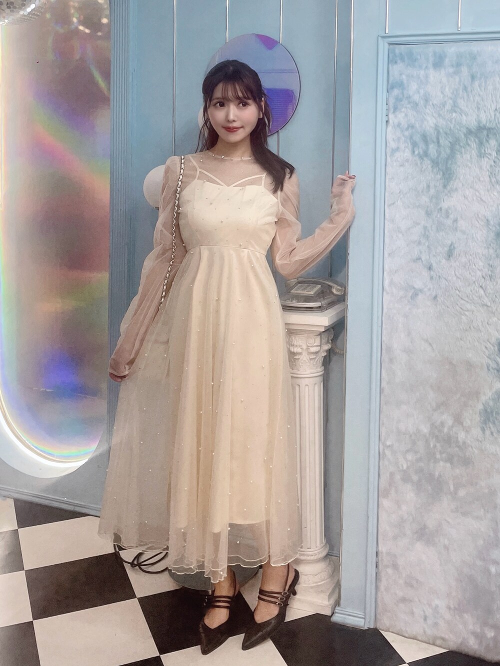 ホワイト系のワンピース、ブラック系のパンプス、ホワイト系のハンドバッグを着用したレディースの秋コーディネートの3枚目の写真