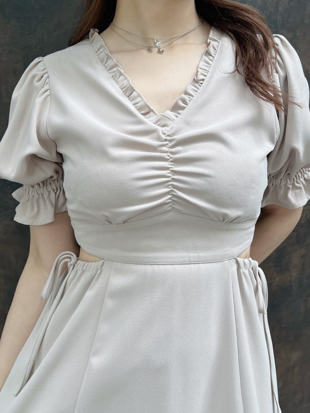 ブラック系のハンドバッグ、ベージュ系のワンピース、ブラック系のサンダルを着用したレディースの春コーディネートの4枚目の写真