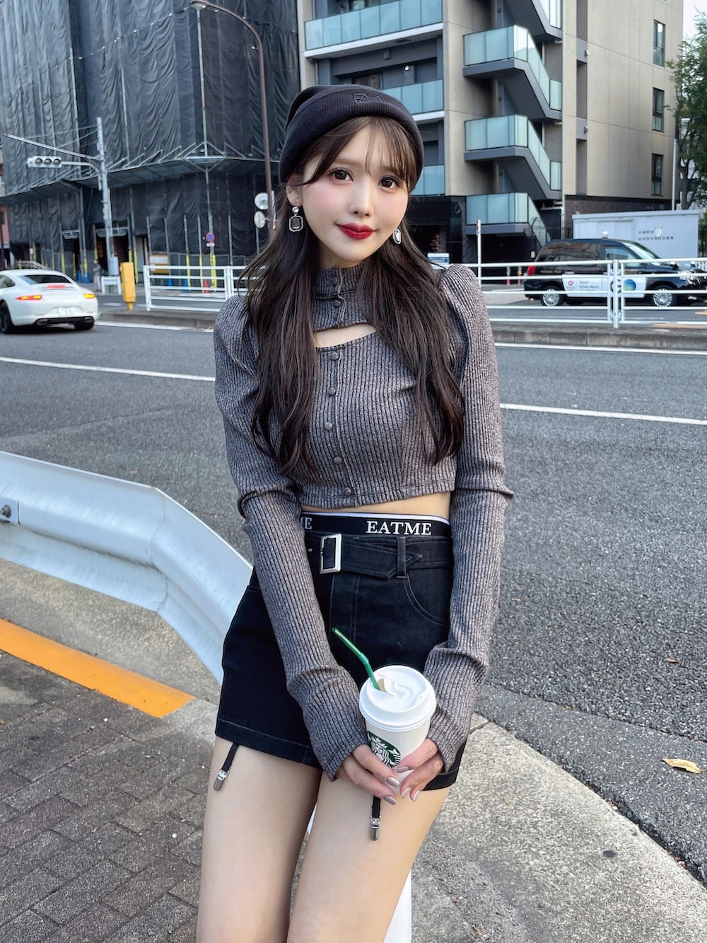 グレー系のTシャツ/カットソー、ブラック系のスカート、ブラック系のブーツを着用したレディースの秋コーディネートの6枚目の写真