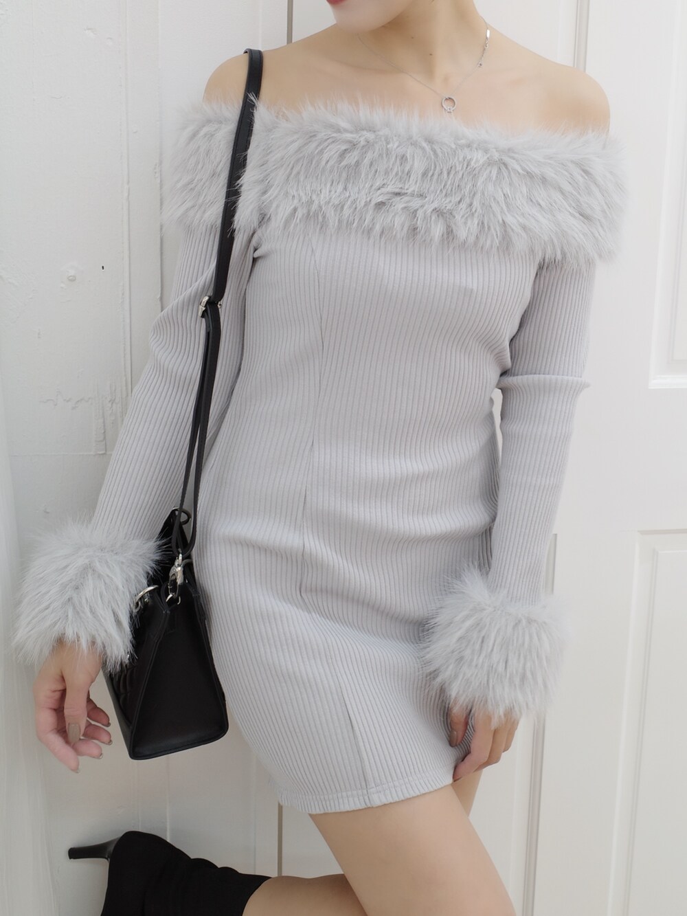 グレー系のワンピース、ブラック系のブーツ、ブラック系のハンドバッグを着用したレディースの秋コーディネートの6枚目の写真