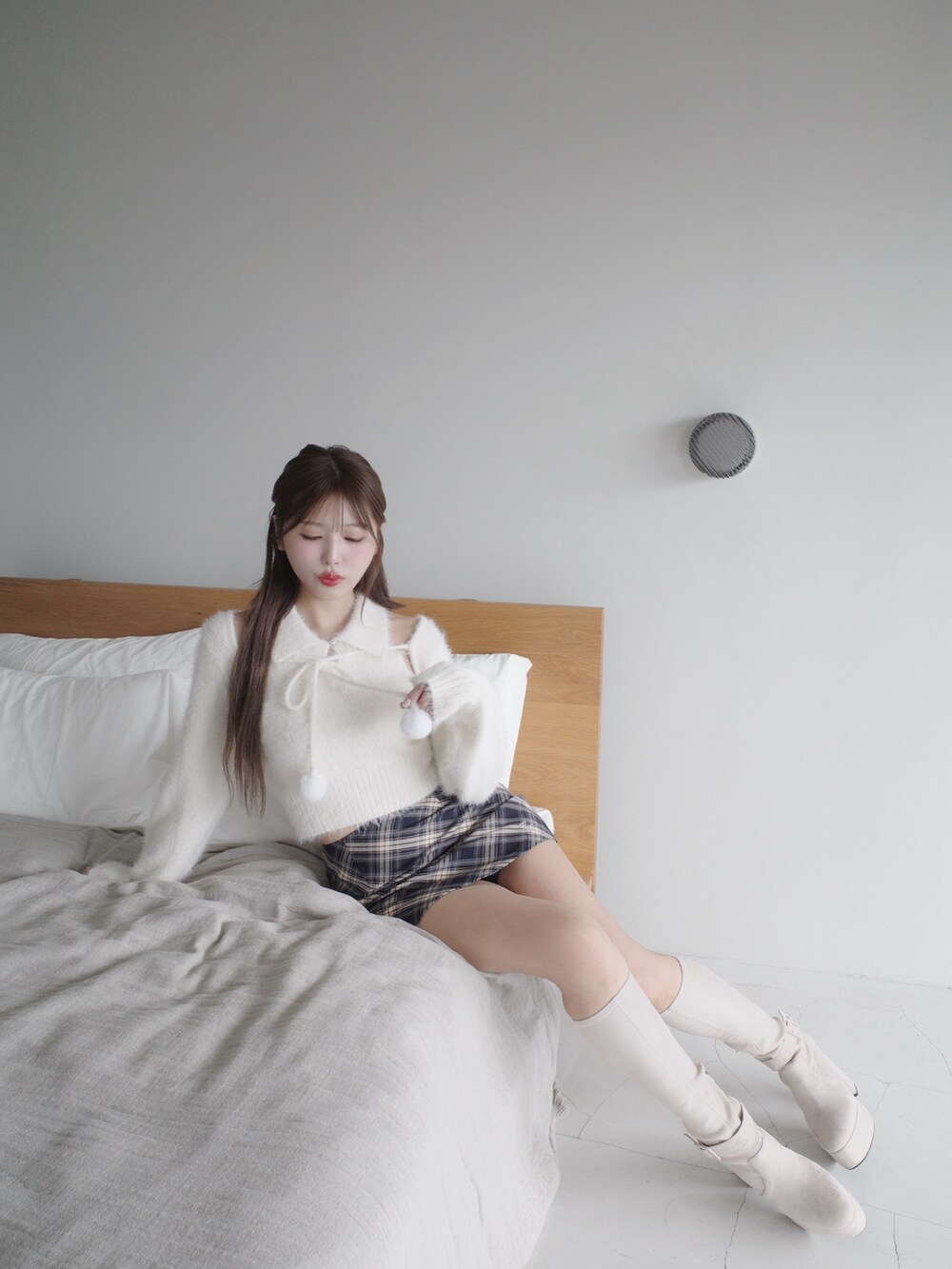 ホワイト系のニット/セーター、ブルー系のスカート、ホワイト系のブーツを着用したレディースの秋コーディネートの7枚目の写真