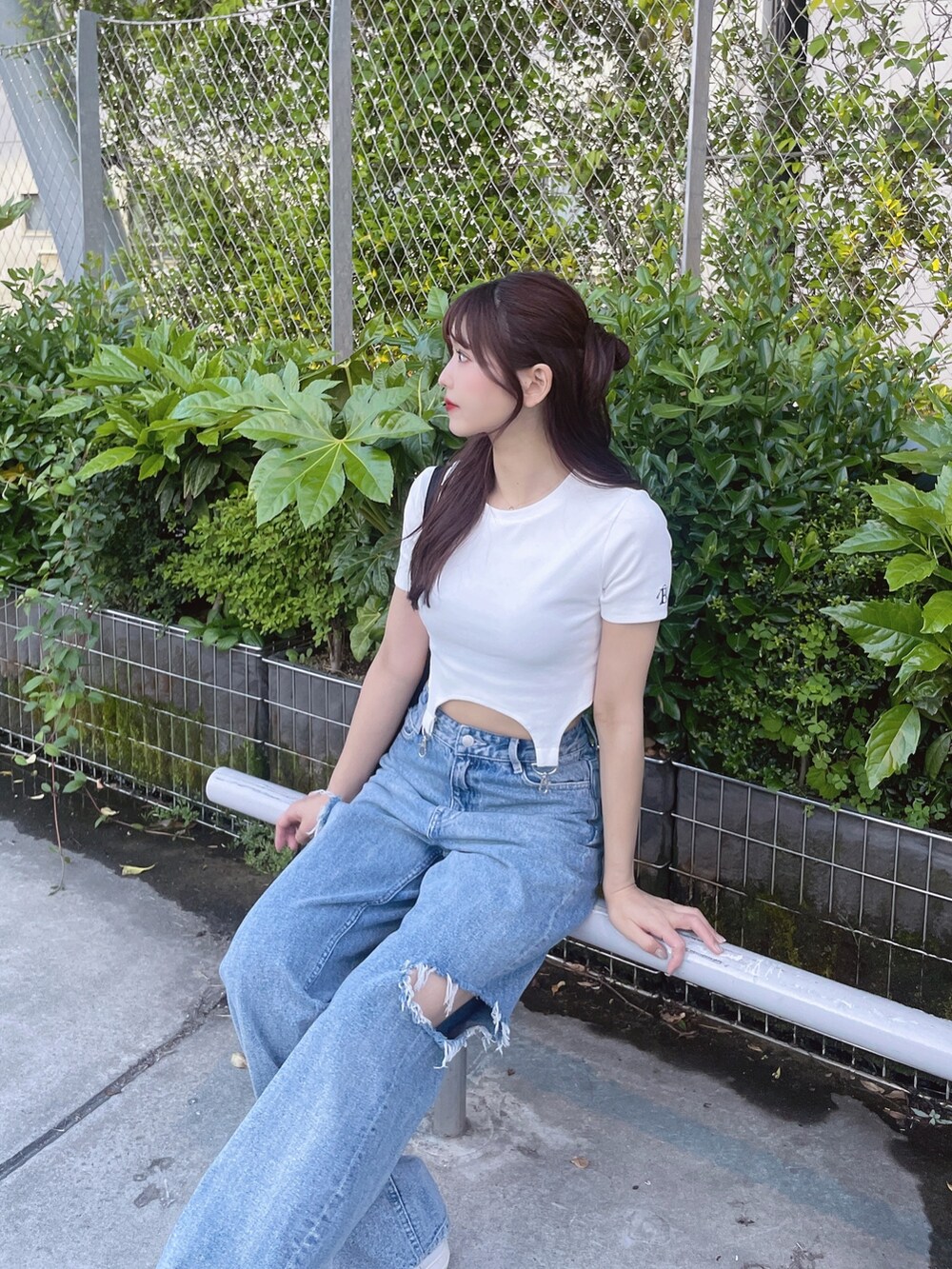 ブルー系のデニムパンツ、ホワイト系のTシャツ/カットソー、ブラック系のショルダーバッグを着用したレディースの春コーディネートの5枚目の写真