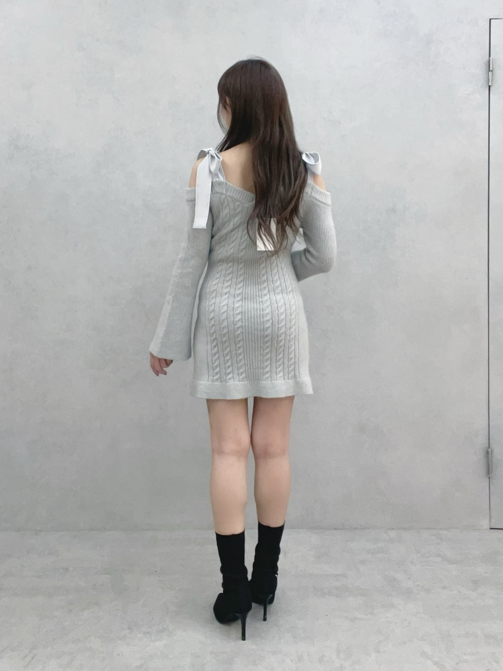 グレー系のワンピース、ブラック系のブーツを着用したレディースの冬コーディネートの4枚目の写真