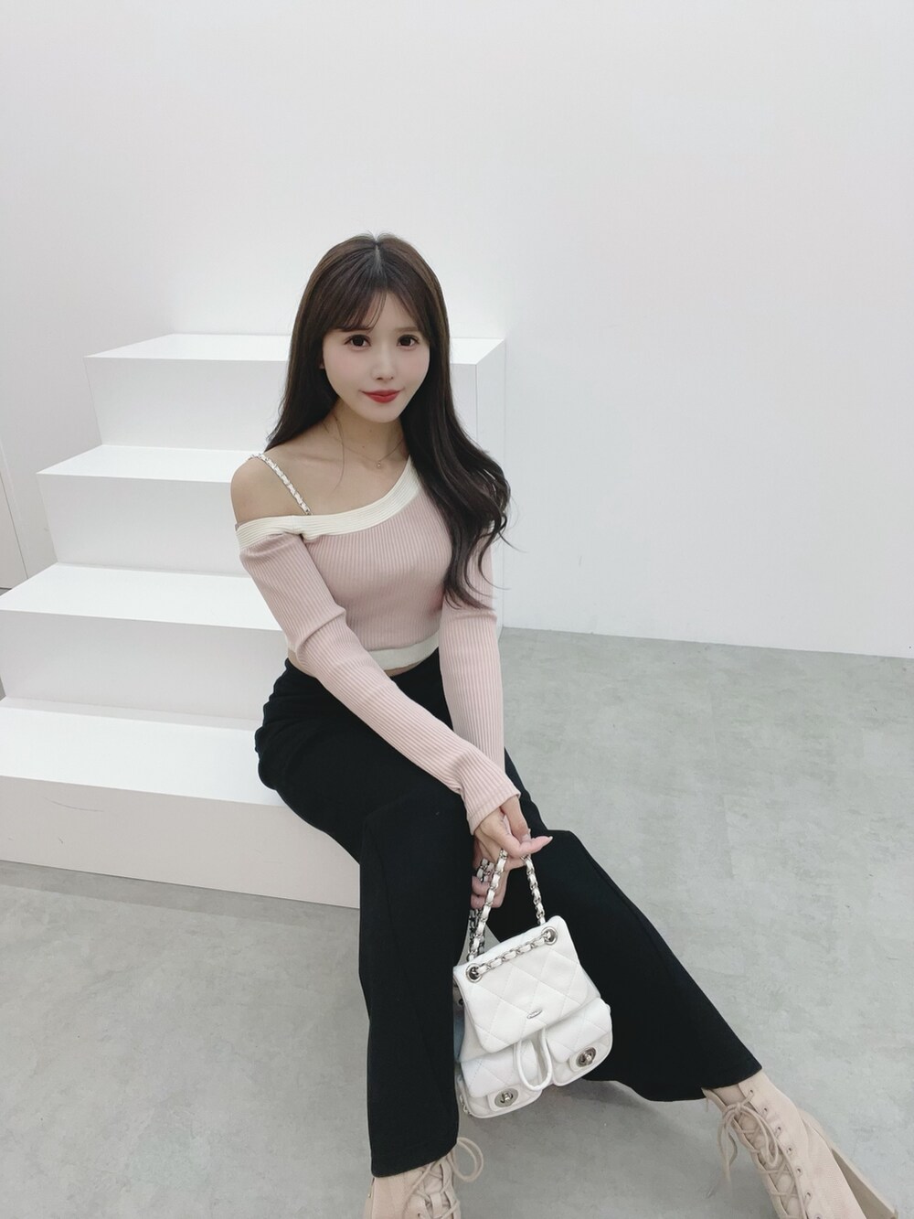 ピンク系のTシャツ/カットソー、ブラック系のその他パンツ、ホワイト系のバックパック/リュックを着用したレディースの冬コーディネートの5枚目の写真