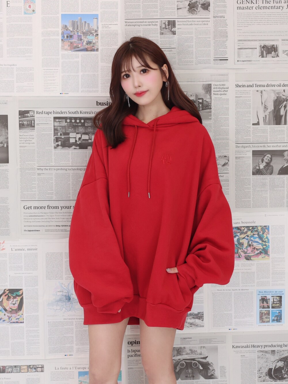 レッド系のパーカー、ブラック系のショルダーバッグ、ブラック系のブーツを着用したレディースの夏コーディネートの2枚目の写真