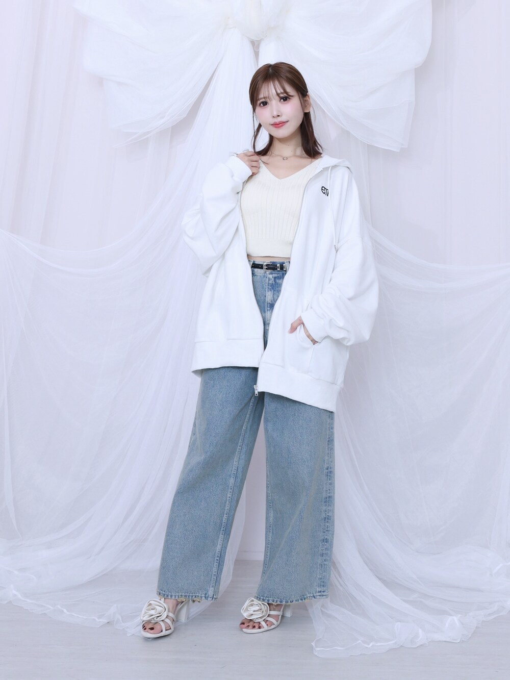 ホワイト系のパーカー、ブルー系のデニムパンツを着用したレディースの冬コーディネートの2枚目の写真