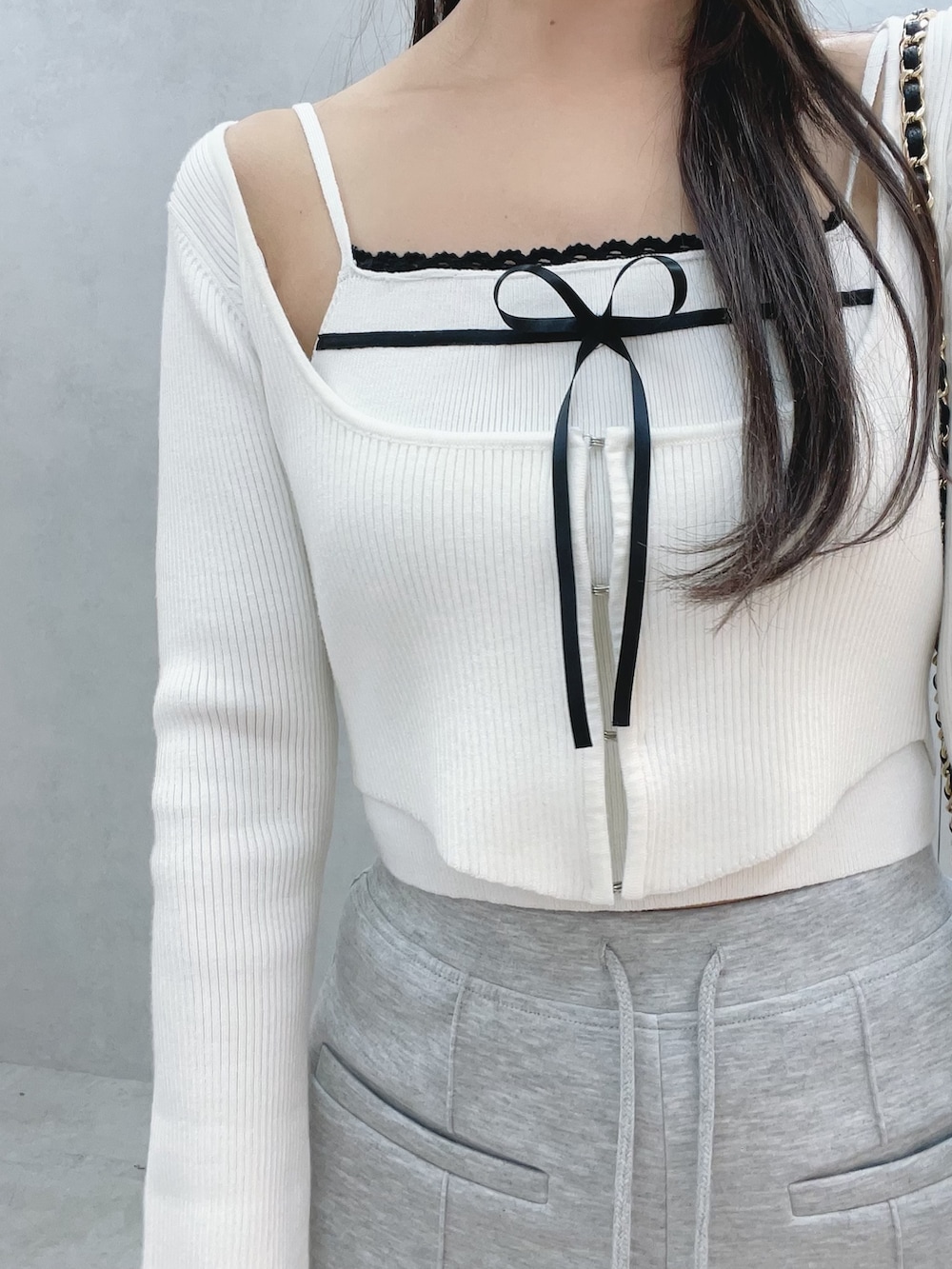 ホワイト系のニット/セーター、グレー系のその他パンツ、ブラック系のバックパック/リュックを着用したレディースの冬コーディネートの8枚目の写真