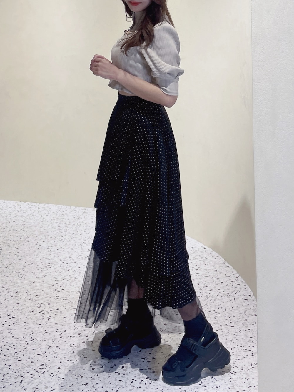 ベージュ系のニット/セーター、その他のスカート、ブラック系のサンダルを着用したレディースの冬コーディネートの3枚目の写真