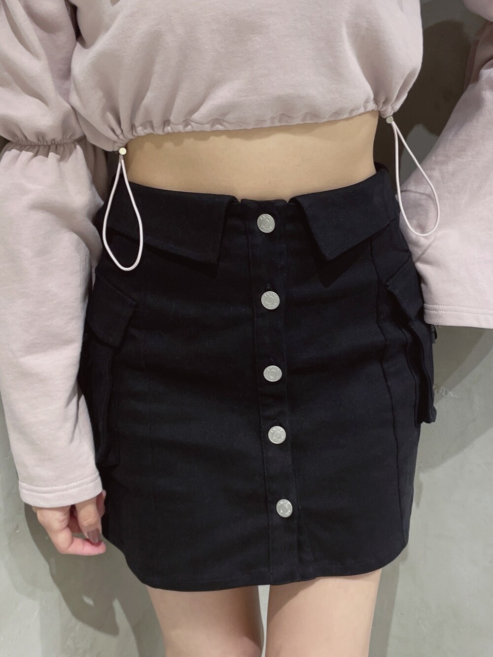 ピンク系のスウェット、ブラック系のスカートを着用したレディースの冬コーディネートの6枚目の写真