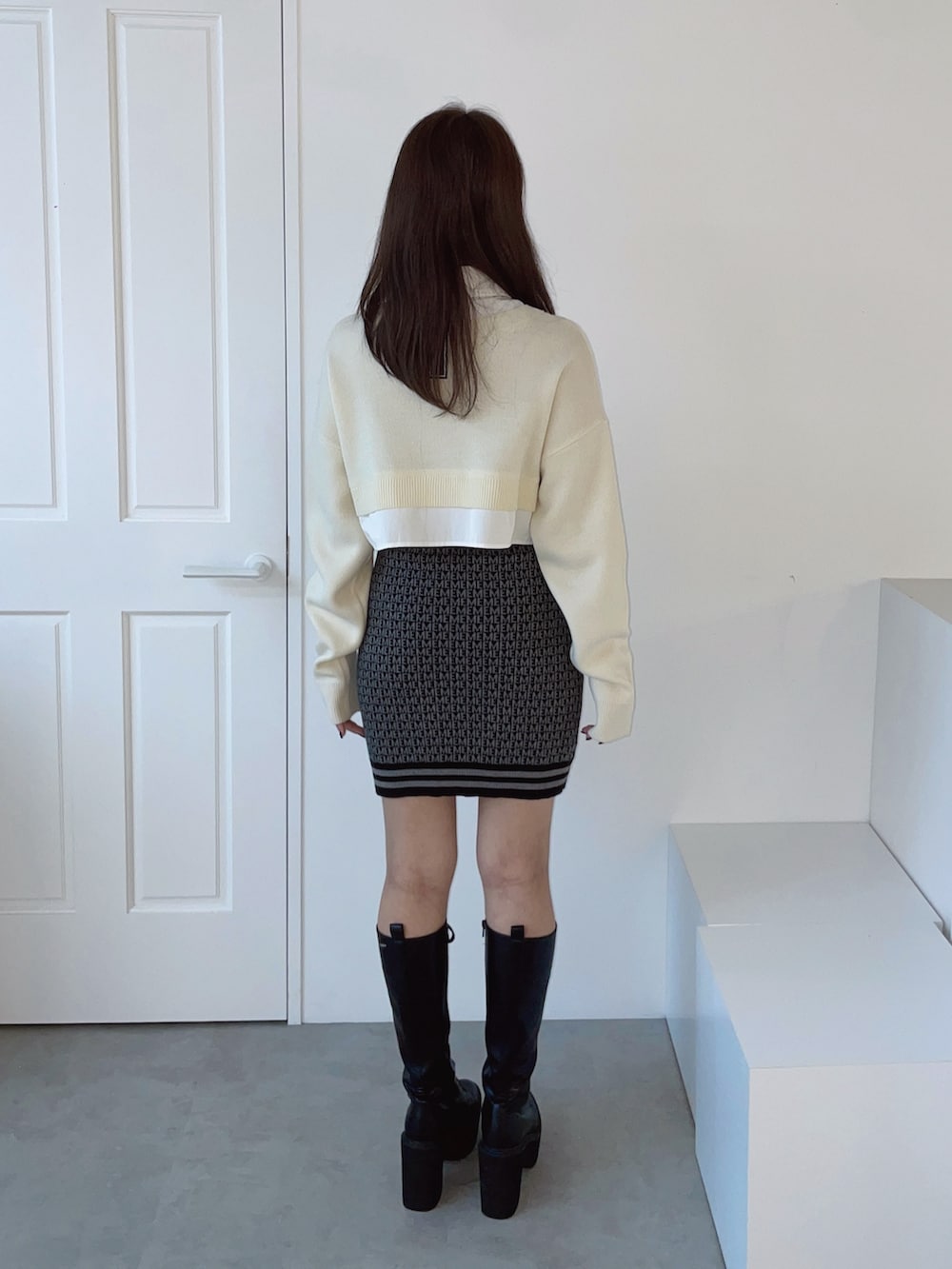 ホワイト系のシャツ/ブラウス、ブラック系のスカート、ブラック系のブーツを着用したレディースの秋コーディネートの8枚目の写真