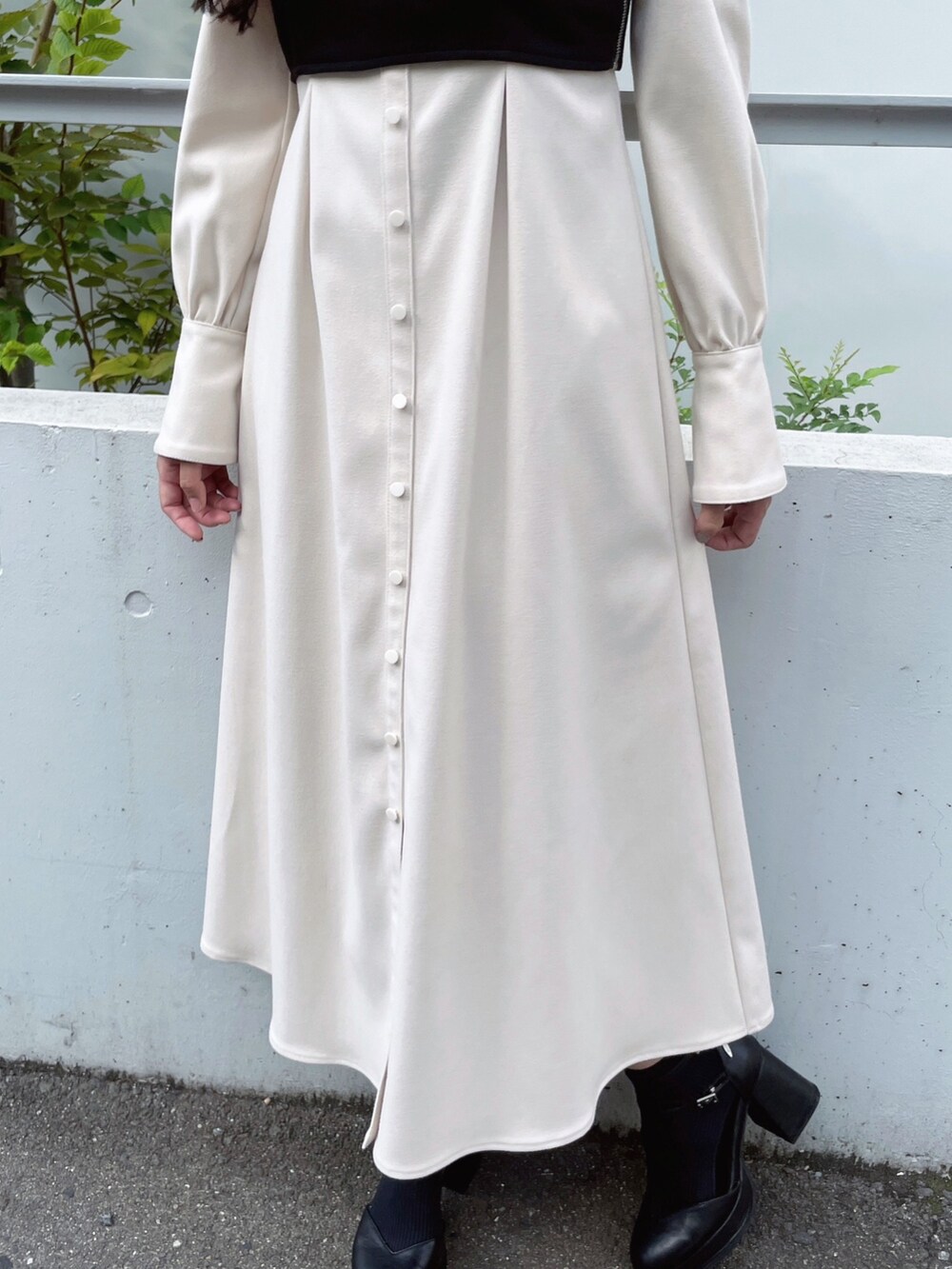 ホワイト系のワンピース、ブラック系のパンプス、ブラック系のピアス（両耳用）を着用したレディースの秋コーディネートの9枚目の写真