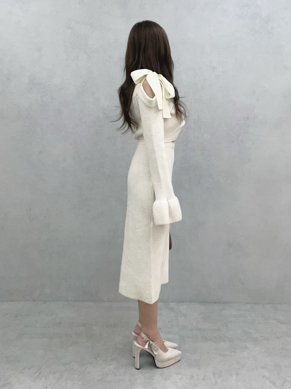 ブラウン系のショルダーバッグ、ホワイト系のワンピースを着用したレディースの冬コーディネートの3枚目の写真