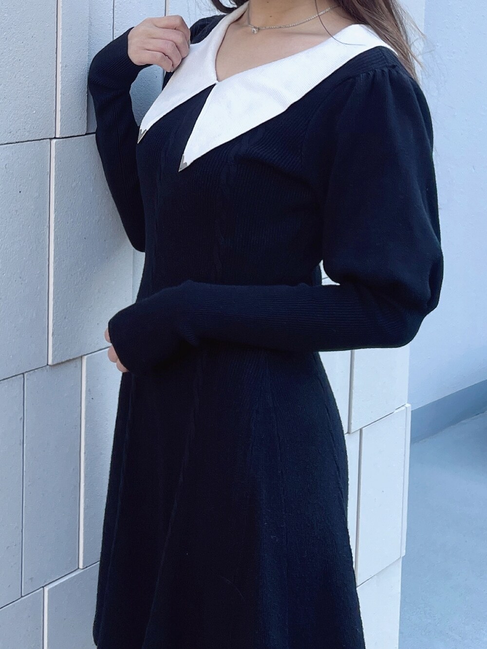 ブラック系のワンピース、レッド系のパンプス、シルバー系のネックレスを着用したレディースの冬コーディネートの5枚目の写真