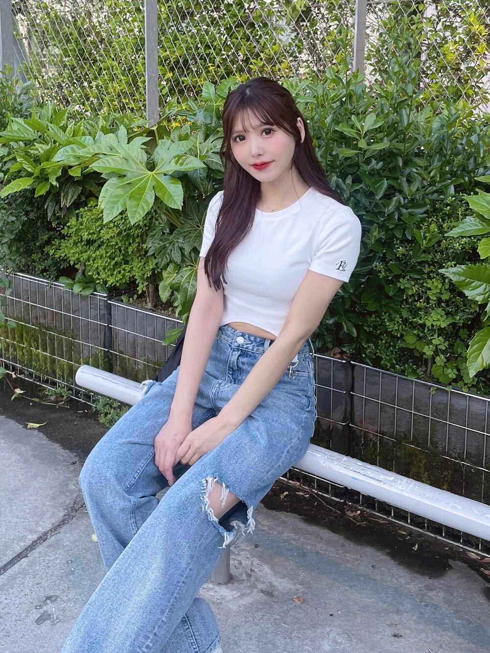 ブルー系のデニムパンツ、ホワイト系のTシャツ/カットソー、ブラック系のショルダーバッグを着用したレディースの春コーディネートの6枚目の写真