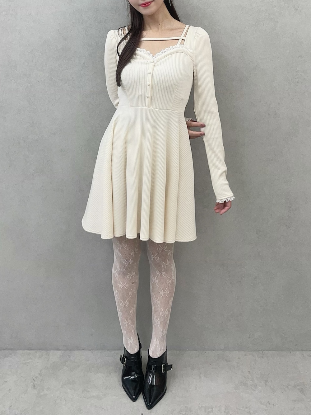 ホワイト系のワンピース、ブラック系のブーツを着用したレディースの冬コーディネートの3枚目の写真