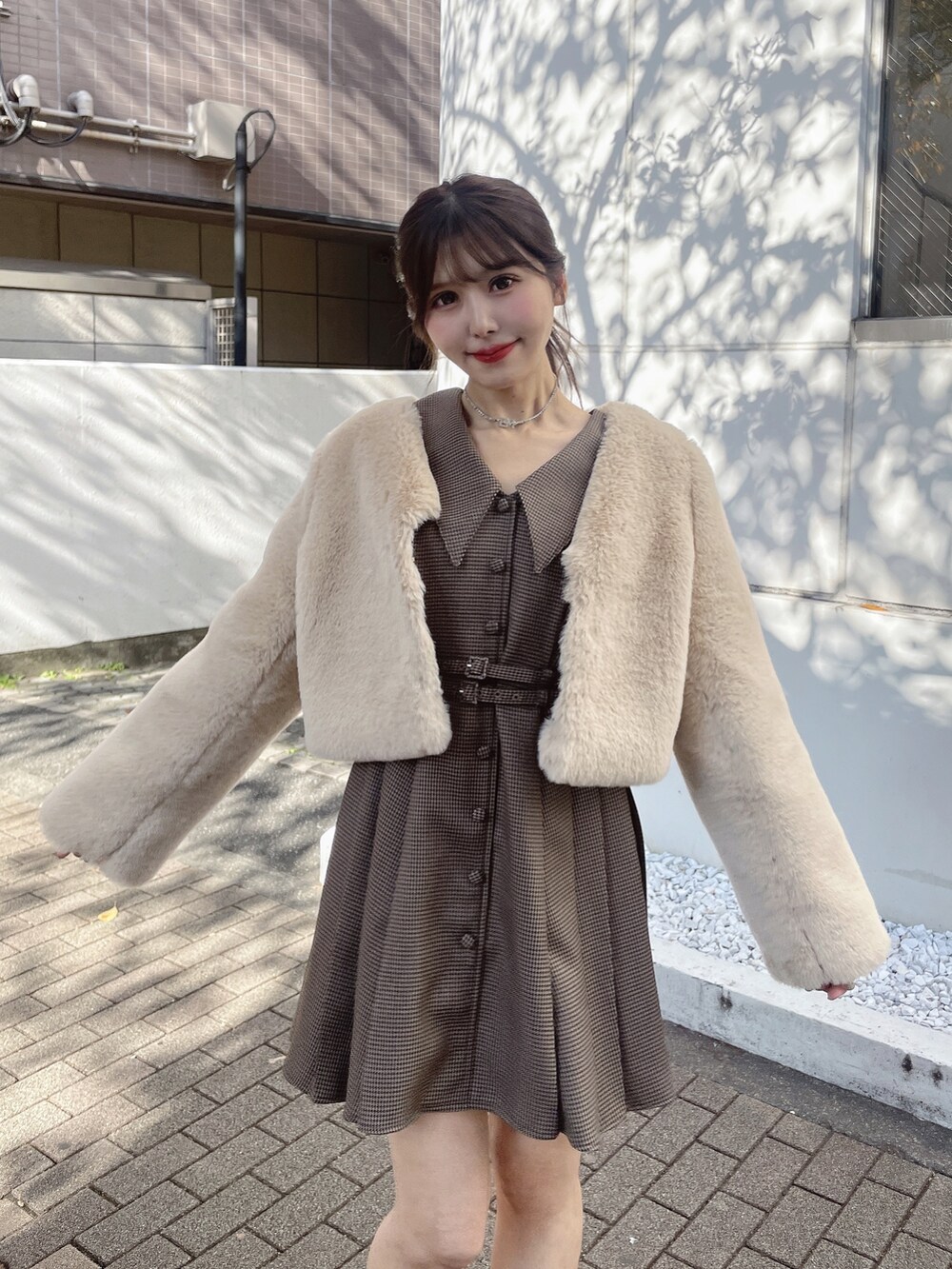 ブラウン系のワンピース、ベージュ系のその他アウター、ブラック系のローファーを着用したレディースの冬コーディネートの3枚目の写真