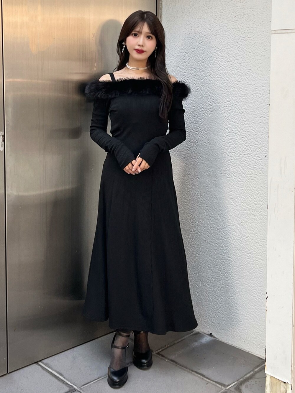 ブラック系のワンピース、ブラック系のパンプス、ホワイト系のチョーカーを着用したレディースの秋コーディネートの3枚目の写真