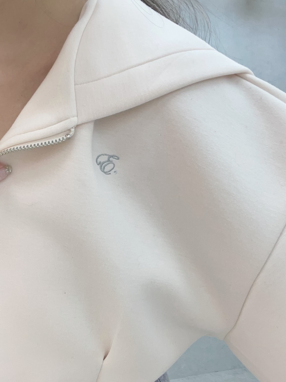 グレー系のワンピース、ホワイト系のパーカー、ホワイト系のブーツを着用したレディースの冬コーディネートの6枚目の写真