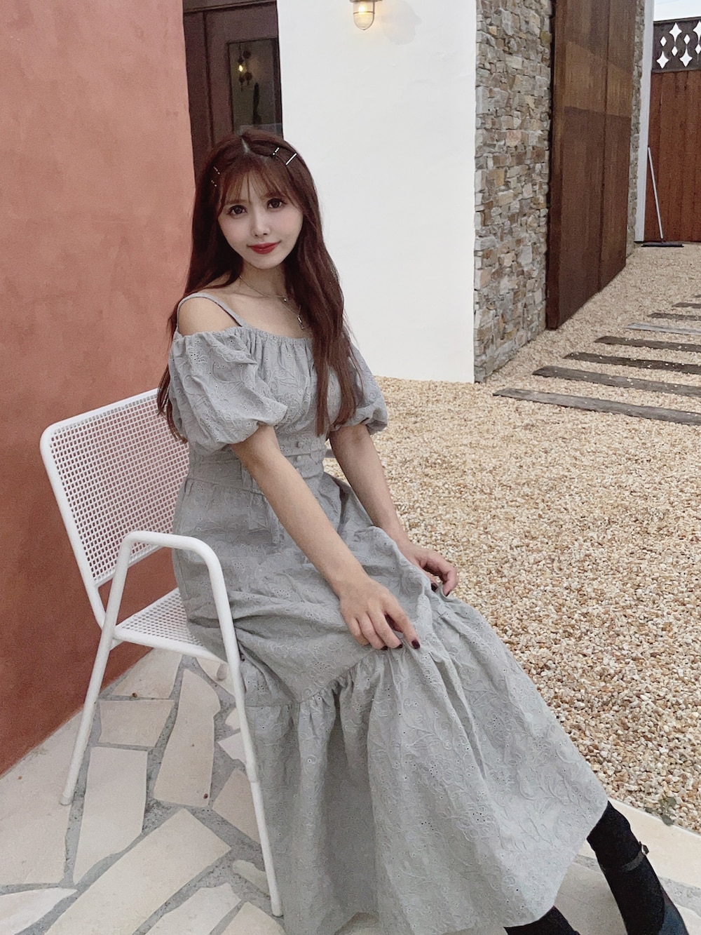 グリーン系のワンピース、ブラック系のパンプスを着用したレディースの春コーディネートの2枚目の写真