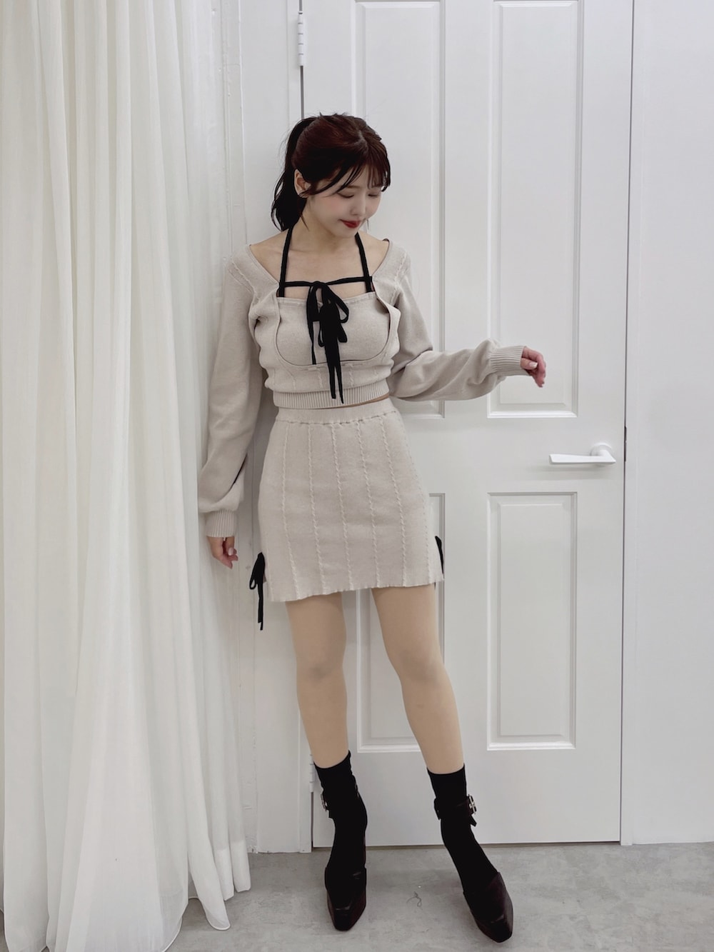 グレー系のニット/セーター、グレー系のスカートを着用したレディースの夏コーディネートの5枚目の写真