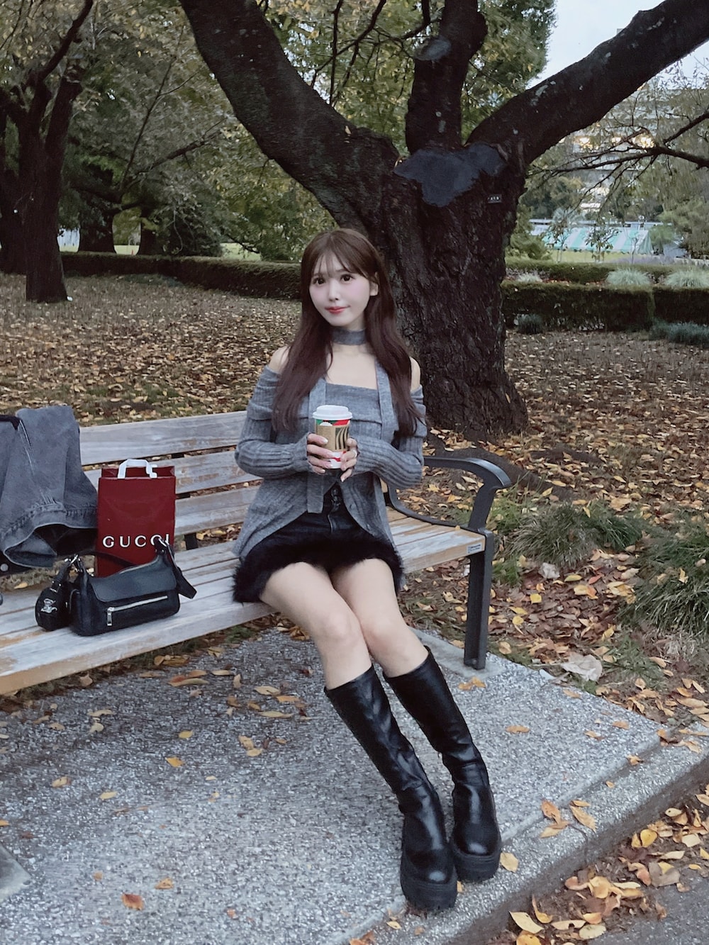 グレー系のニット/セーター、ブラック系のデニムスカートを着用したレディースの秋コーディネートの6枚目の写真